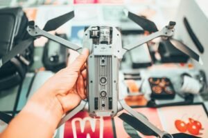Close-up of a person holding a futuristic drone controller with gadgets in the background.