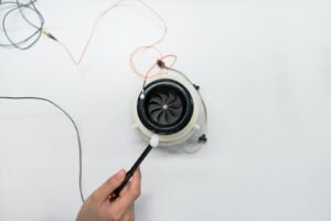 person holding white and black headphones